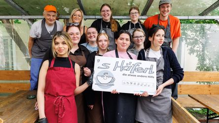 Eine Gruppe von Mitarbeitern von dm Österreich und Mitarbeitern vom Haeferl in Wien stehen zusammen und lächeln glücklich in die Kamera.