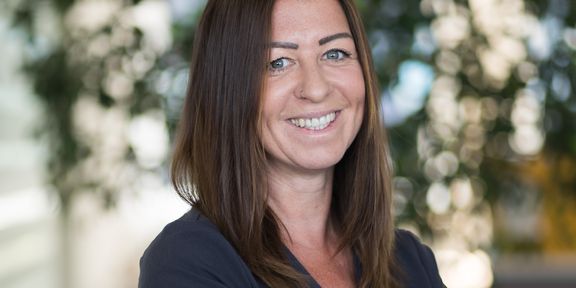 Eine Mitarbeiterin lächelt in die Kamera