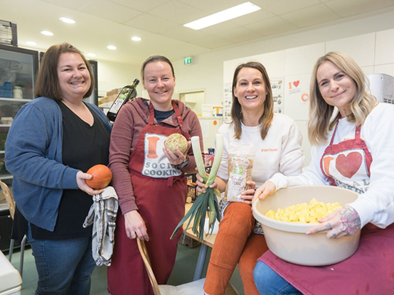 Vier Mitarbeiterinnen beim mehr vom leben Tag. Sie halten verschiedene Lebensmittel in der Hand.