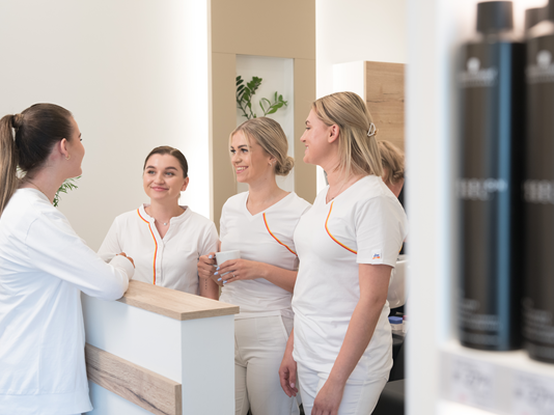 Vier Kosmetikerinnen stehen gemeinsam in der Kaffeepause im dm kosmetikstudio.